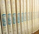 Close-up of beautifully crafted Quran books with intricate Arabic calligraphy on a shelf.